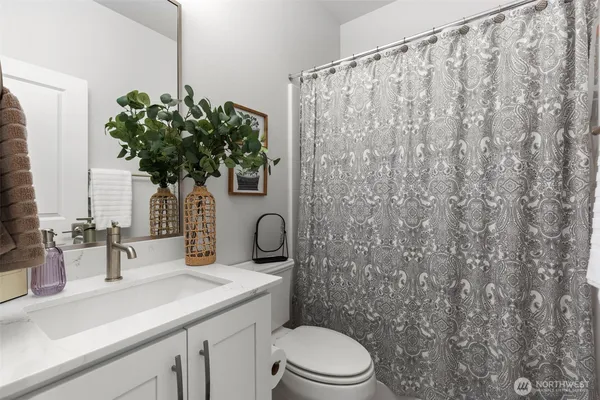 a bathroom with a sink a toilet and mirror