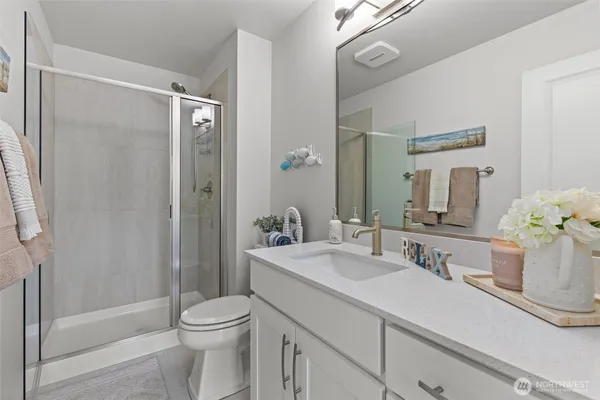 a bathroom with a sink a toilet and shower