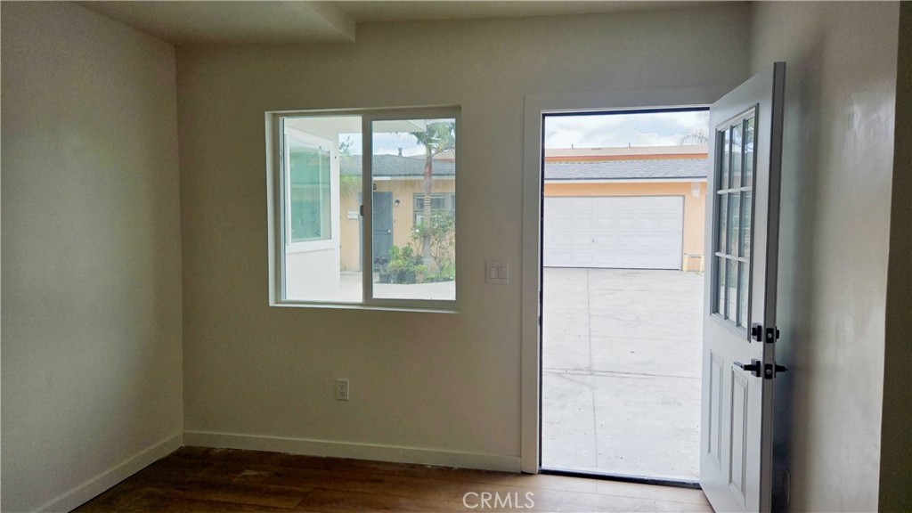 11171 Bullis Road Lynwood, CA 90262 - Photo 3 of 15 a view of an empty room with wooden floor and a window