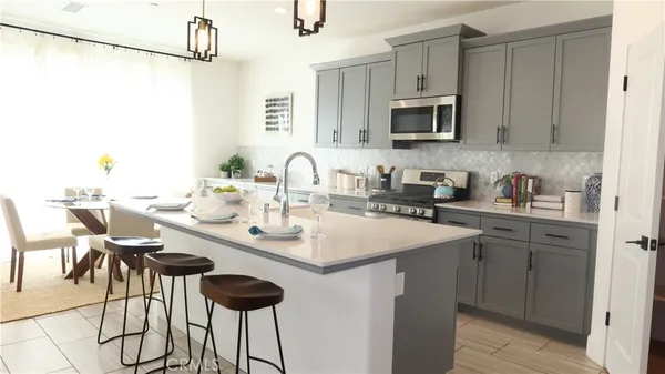 a kitchen with sink a microwave and cabinets