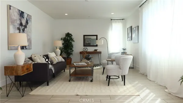 a living room with furniture and a dining table with kitchen view