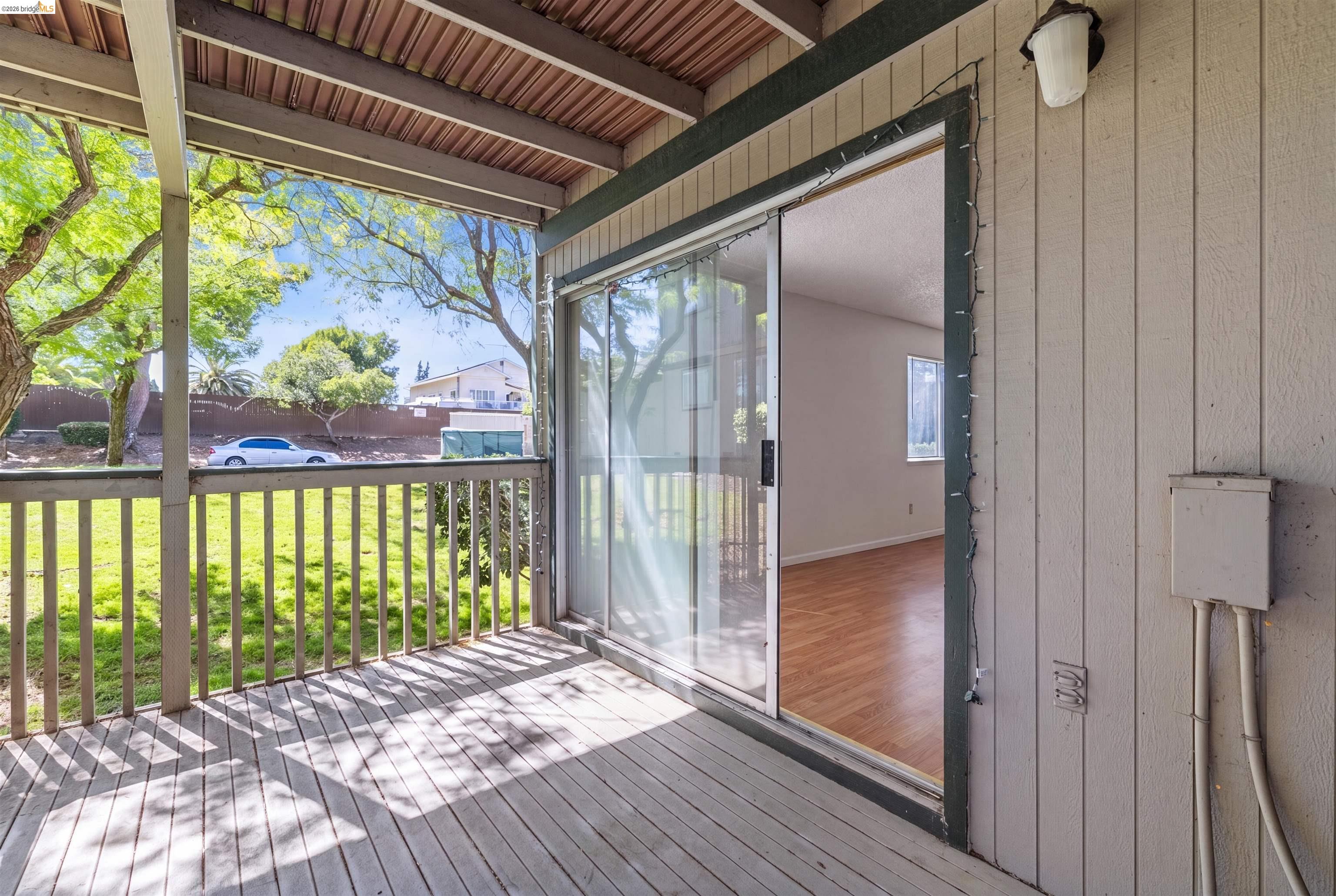 1151 Chadwick Circle Bay Point, CA 94565 - Photo 21 of 23 Covered wood-plank patio with a wood railing, offering outdoor access through a glass sliding door