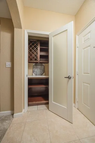 a view of an empty room with kitchen and a window