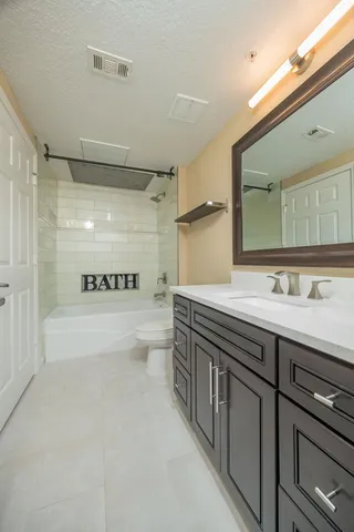 a bathroom with a double vanity sink toilet and shower