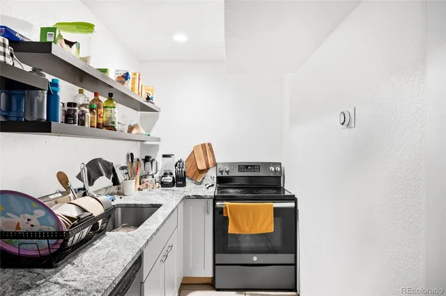 a kitchen with sink a stove and cabinets