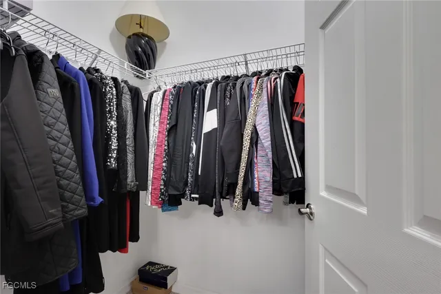 a view of walk in closet with clothes