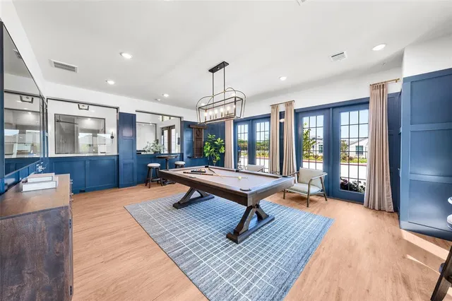 a living room with furniture a large window and wooden floor