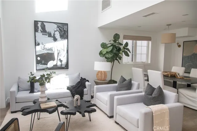 a living room with furniture a large window and stainless steel appliances