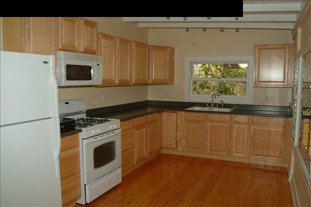 471 Pulehuiki Road Kula, HI 96790 - Photo 6 of 30 a kitchen with granite countertop white cabinets and white appliances