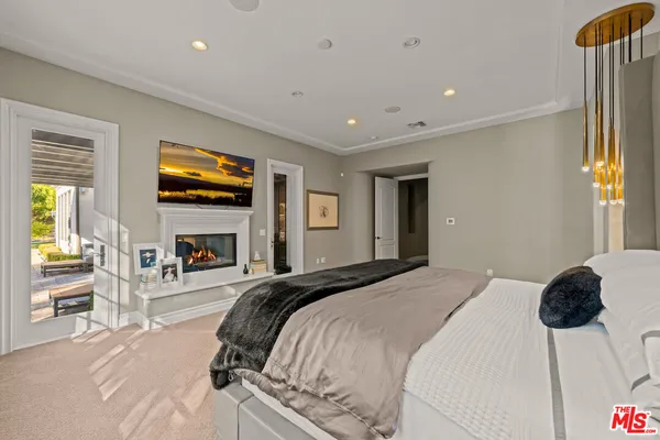 a spacious bedroom with a bed and a flat screen tv