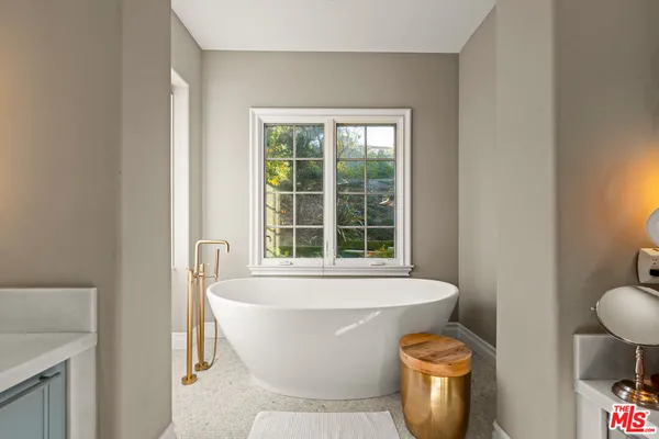 a white bath tub sitting in a bathroom next to a window