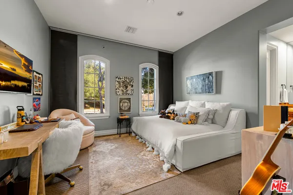 a bedroom with bed and a large window