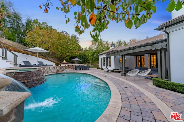 a view of a house with backyard sitting area and swimming pool