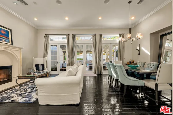 a living room with furniture a fireplace and floor to ceiling windows