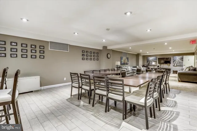 a kitchen with granite countertop a refrigerator a stove a dining table and chairs with wooden floor