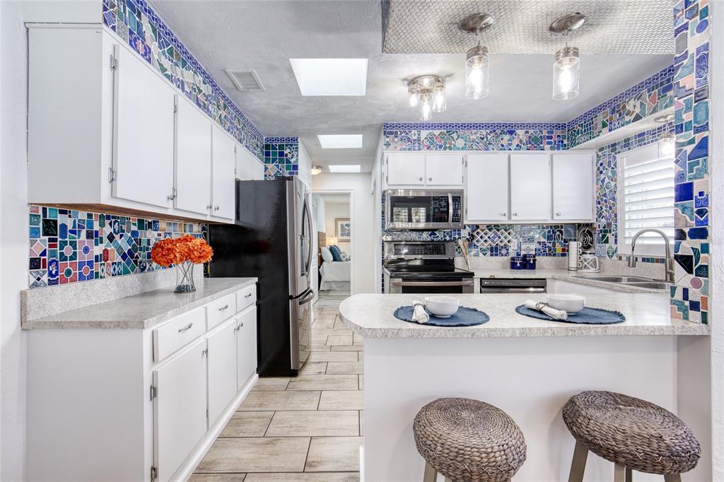 1127 Indigo Road Ormond Beach, FL 32174 - Photo 18 of 94 a kitchen with stainless steel appliances granite countertop a sink refrigerator and cabinets