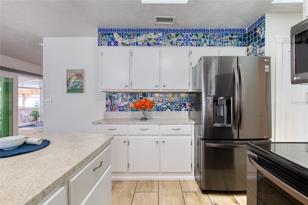1127 Indigo Road Ormond Beach, FL 32174 - Photo 20 of 94 a kitchen with stainless steel appliances a refrigerator sink and cabinets