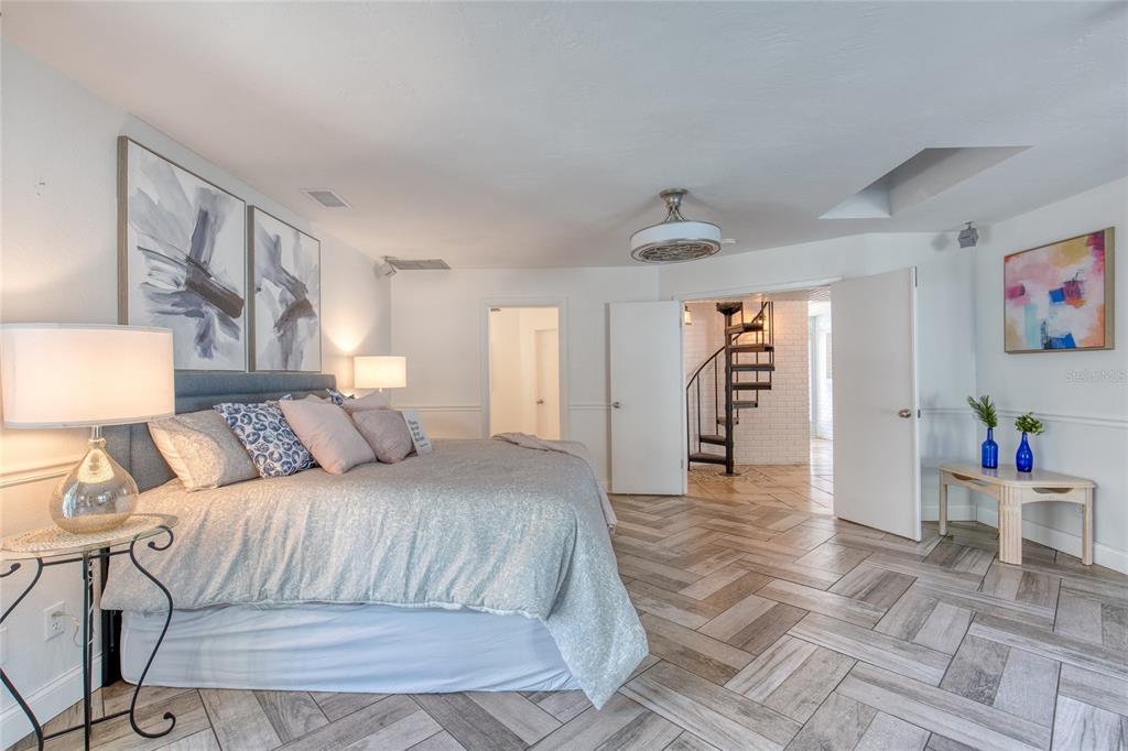 1127 Indigo Road Ormond Beach, FL 32174 - Photo 31 of 94 a bedroom with a large bed and a chandelier