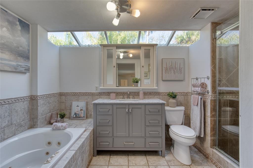 1127 Indigo Road Ormond Beach, FL 32174 - Photo 34 of 94 a bathroom with a granite countertop toilet a sink and a bathtub