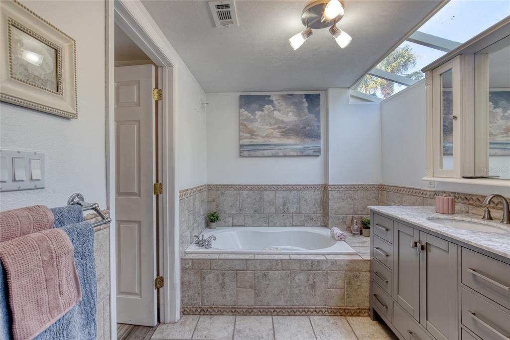 1127 Indigo Road Ormond Beach, FL 32174 - Photo 36 of 94 a bathroom with a tub a sink and mirror