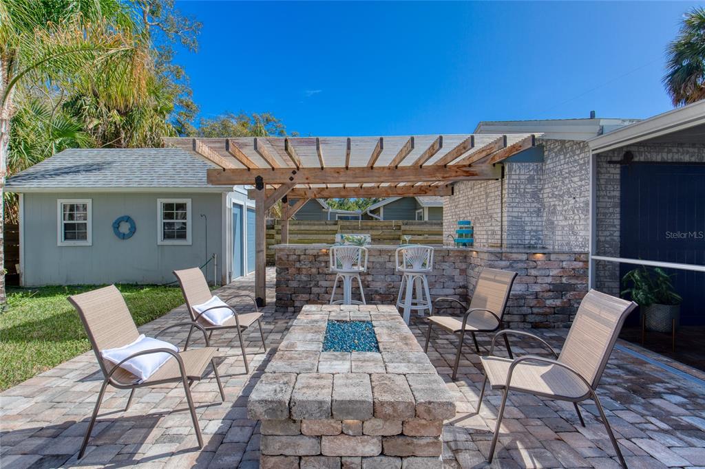 1127 Indigo Road Ormond Beach, FL 32174 - Photo 73 of 94 a view of a patio with a table and chairs under an umbrella
