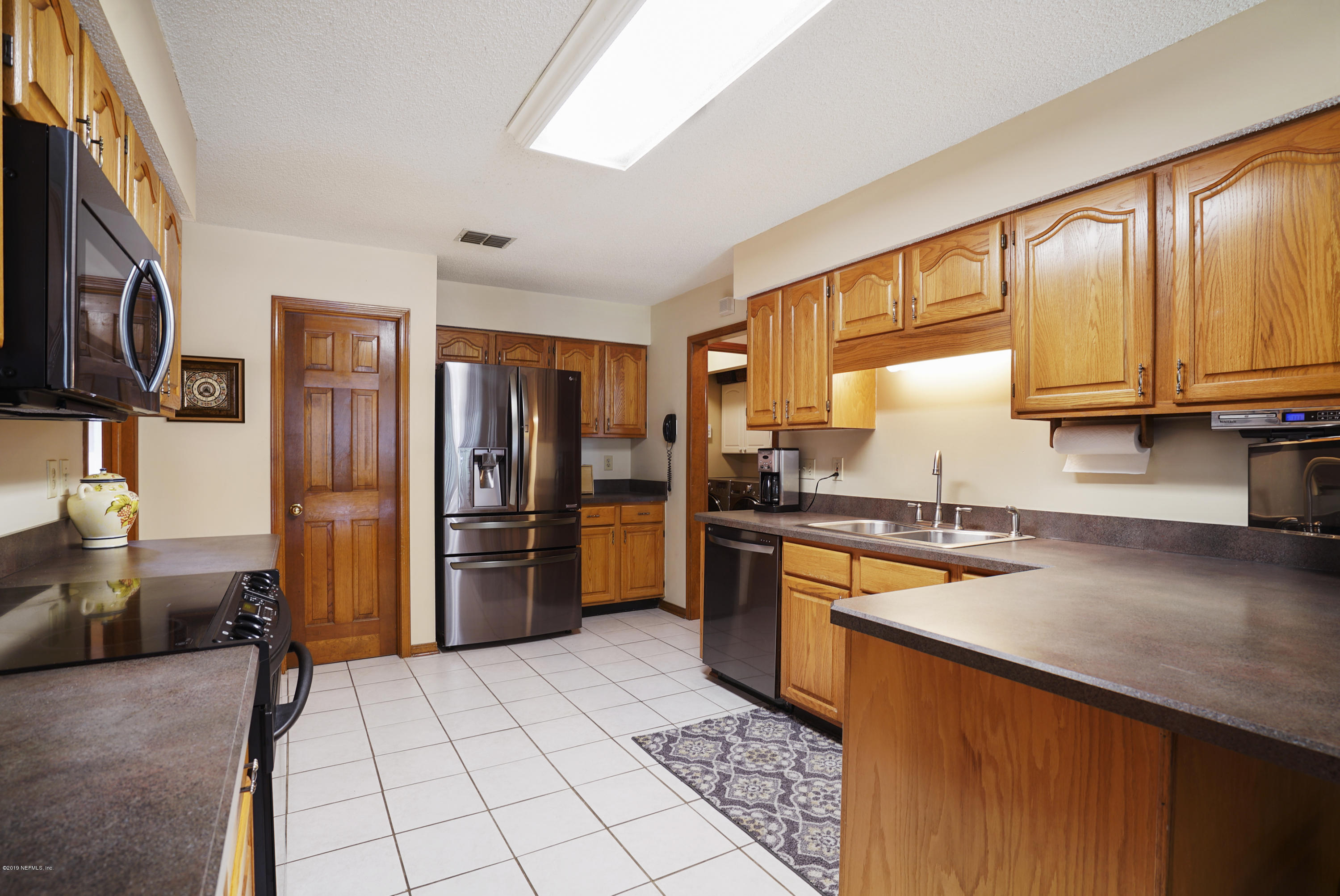3165 Nautilus Road Middleburg, FL 32068 - Photo 11 of 35 a kitchen with stainless steel appliances granite countertop a refrigerator stove top oven a sink dishwasher and cabinets