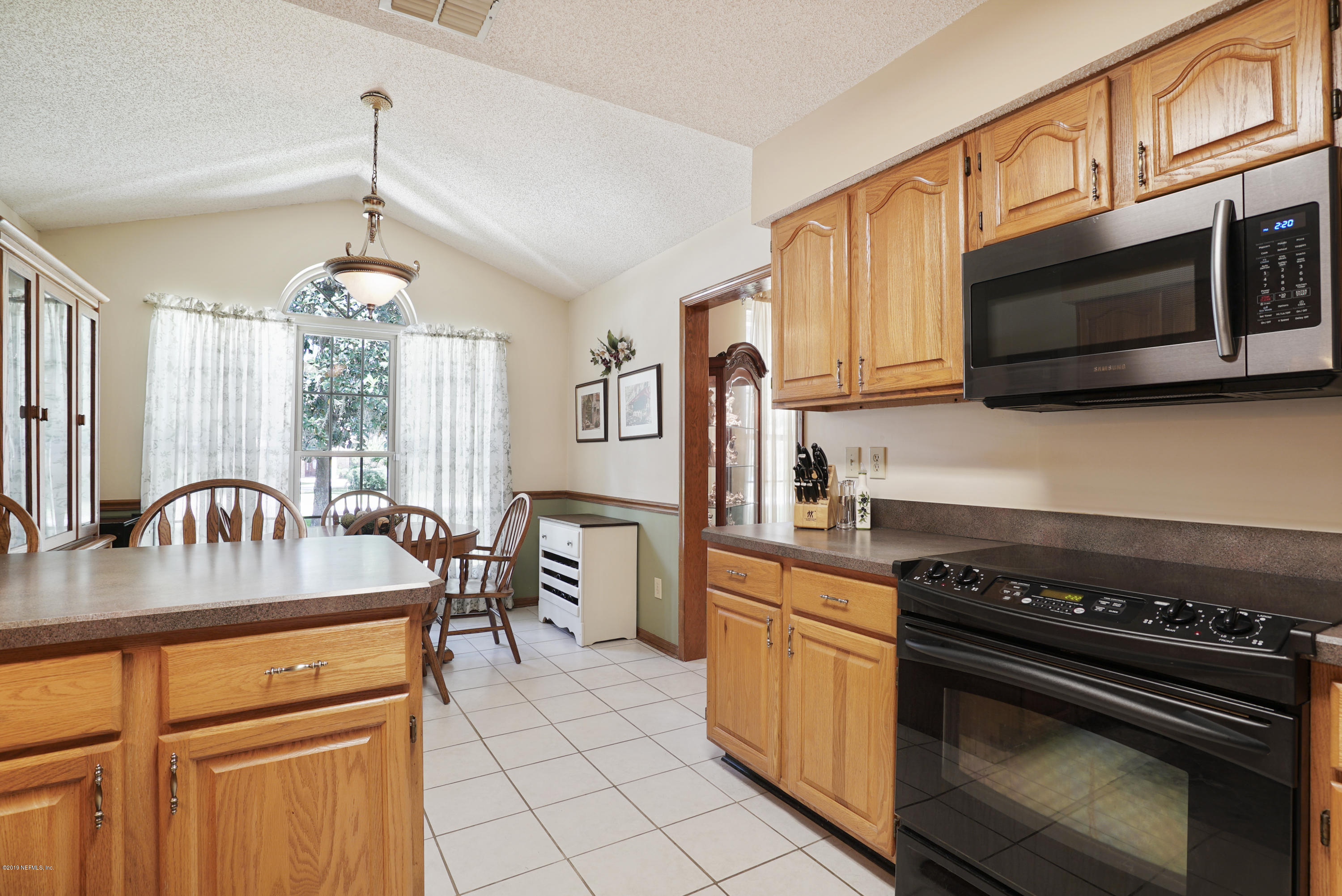 3165 Nautilus Road Middleburg, FL 32068 - Photo 13 of 35 a kitchen with stainless steel appliances granite countertop a stove a sink and a microwave