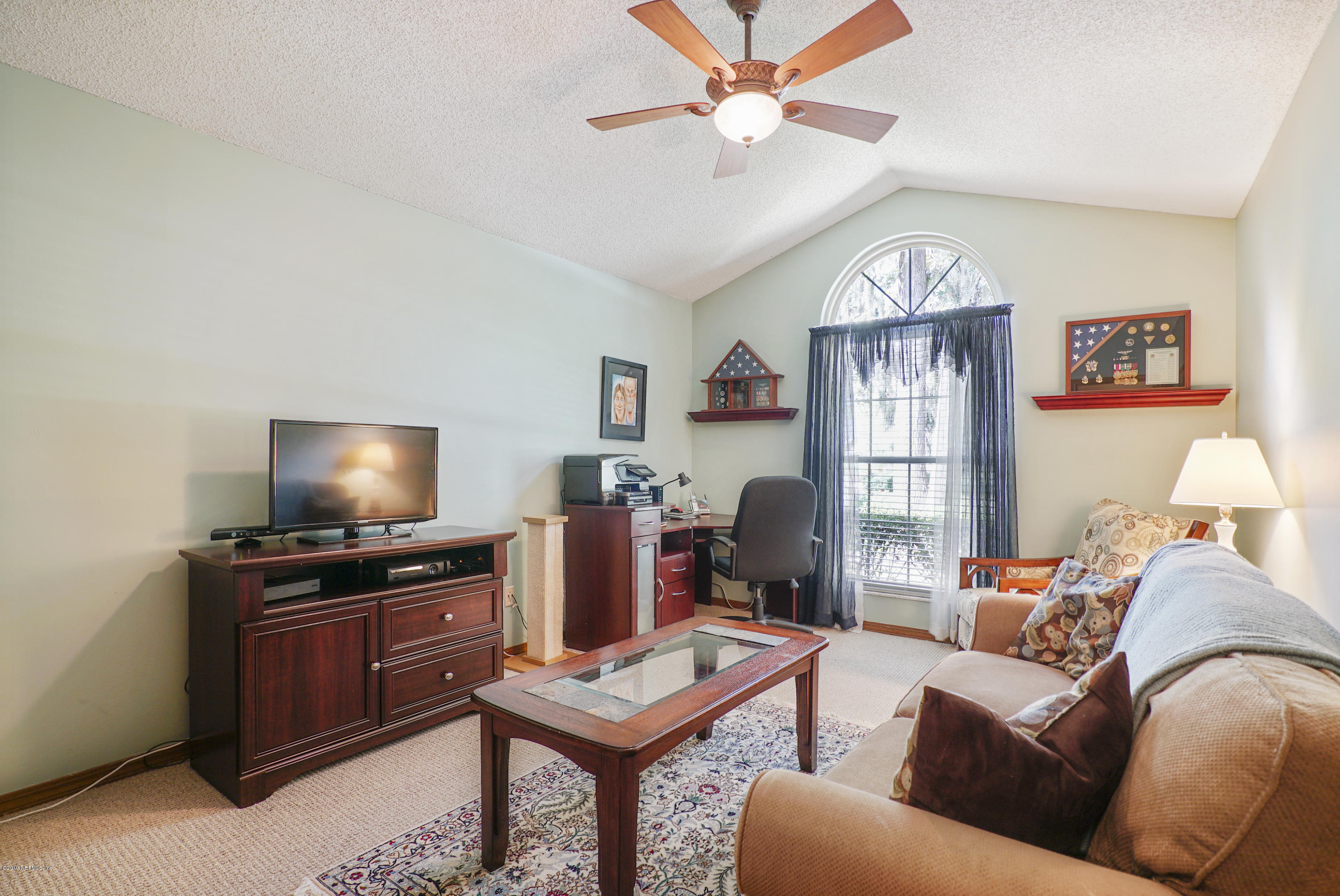 3165 Nautilus Road Middleburg, FL 32068 - Photo 16 of 35 a living room with furniture a large window and a flat screen tv