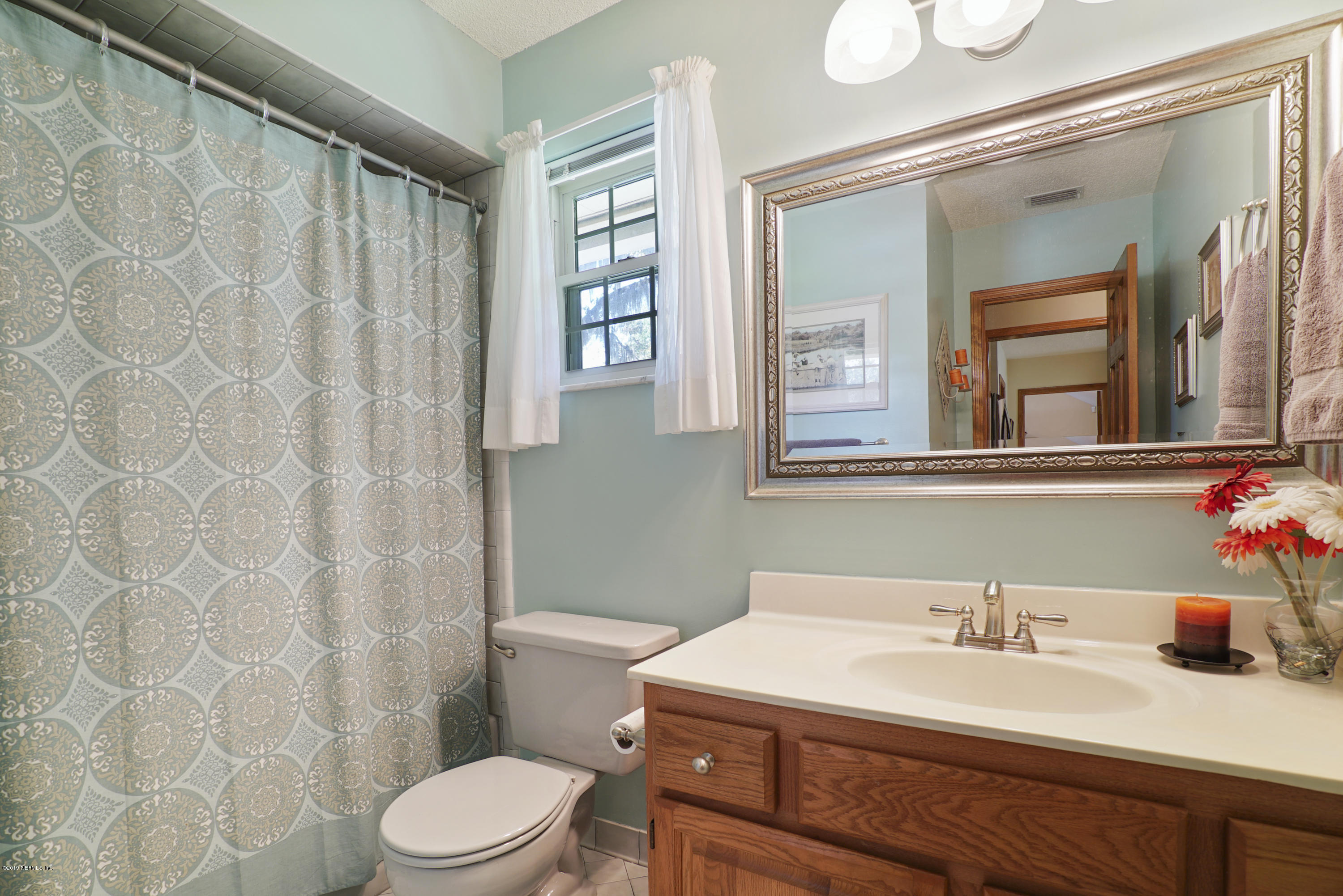 3165 Nautilus Road Middleburg, FL 32068 - Photo 17 of 35 a bathroom with a sink a toilet and a mirror