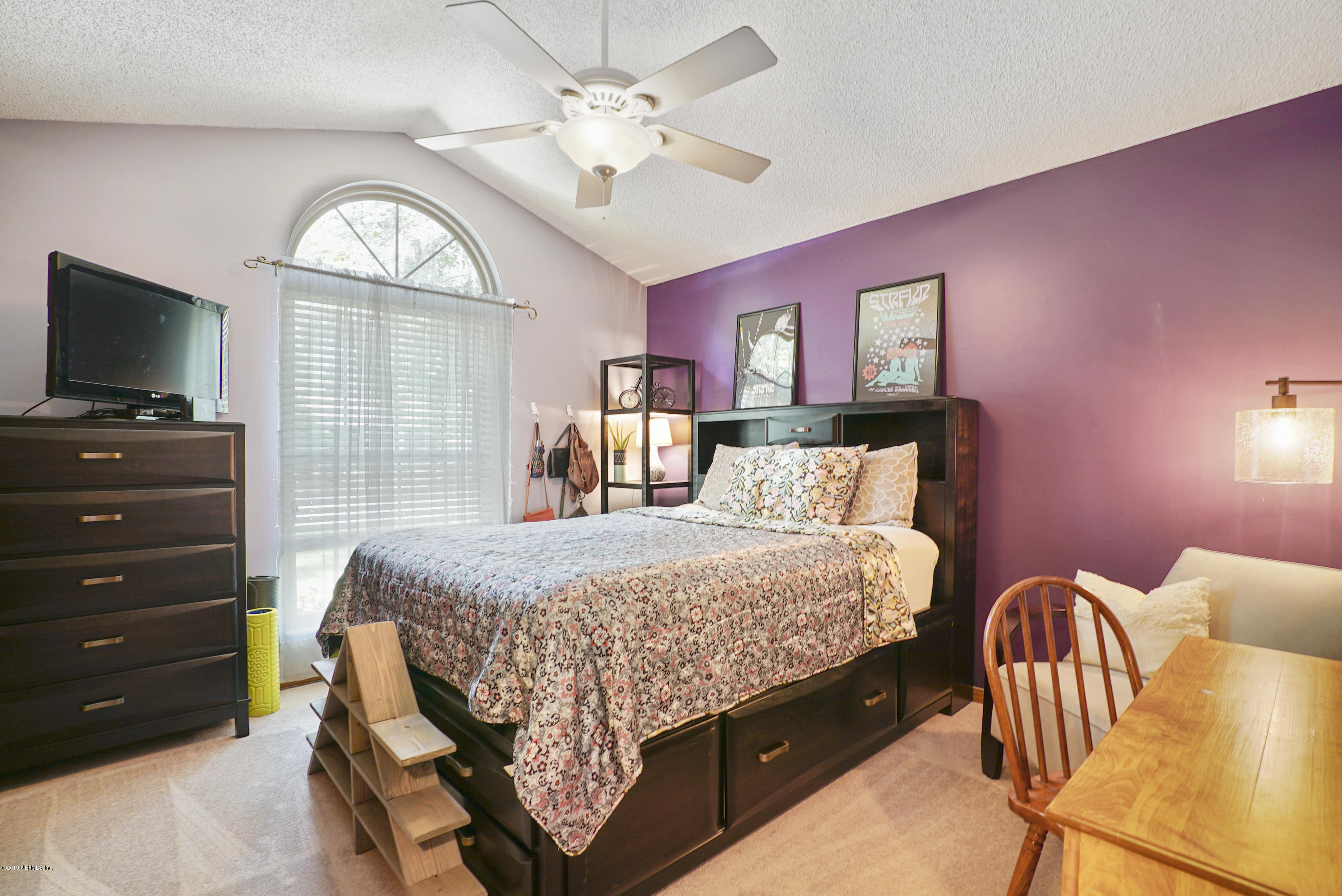 3165 Nautilus Road Middleburg, FL 32068 - Photo 20 of 35 a bedroom with a bed a chandelier and dresser