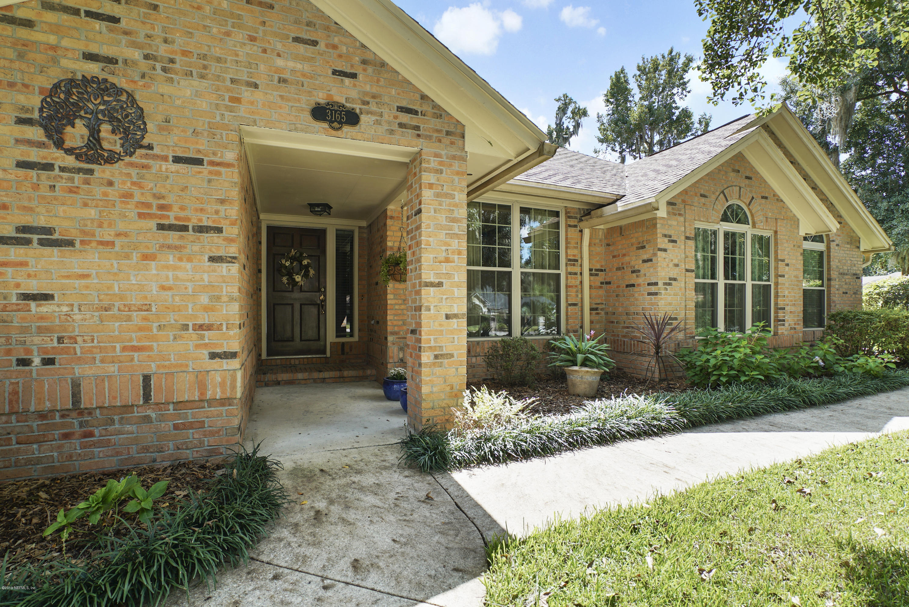 3165 Nautilus Road Middleburg, FL 32068 - Photo 2 of 35 a view of a white house with a large windows and plants