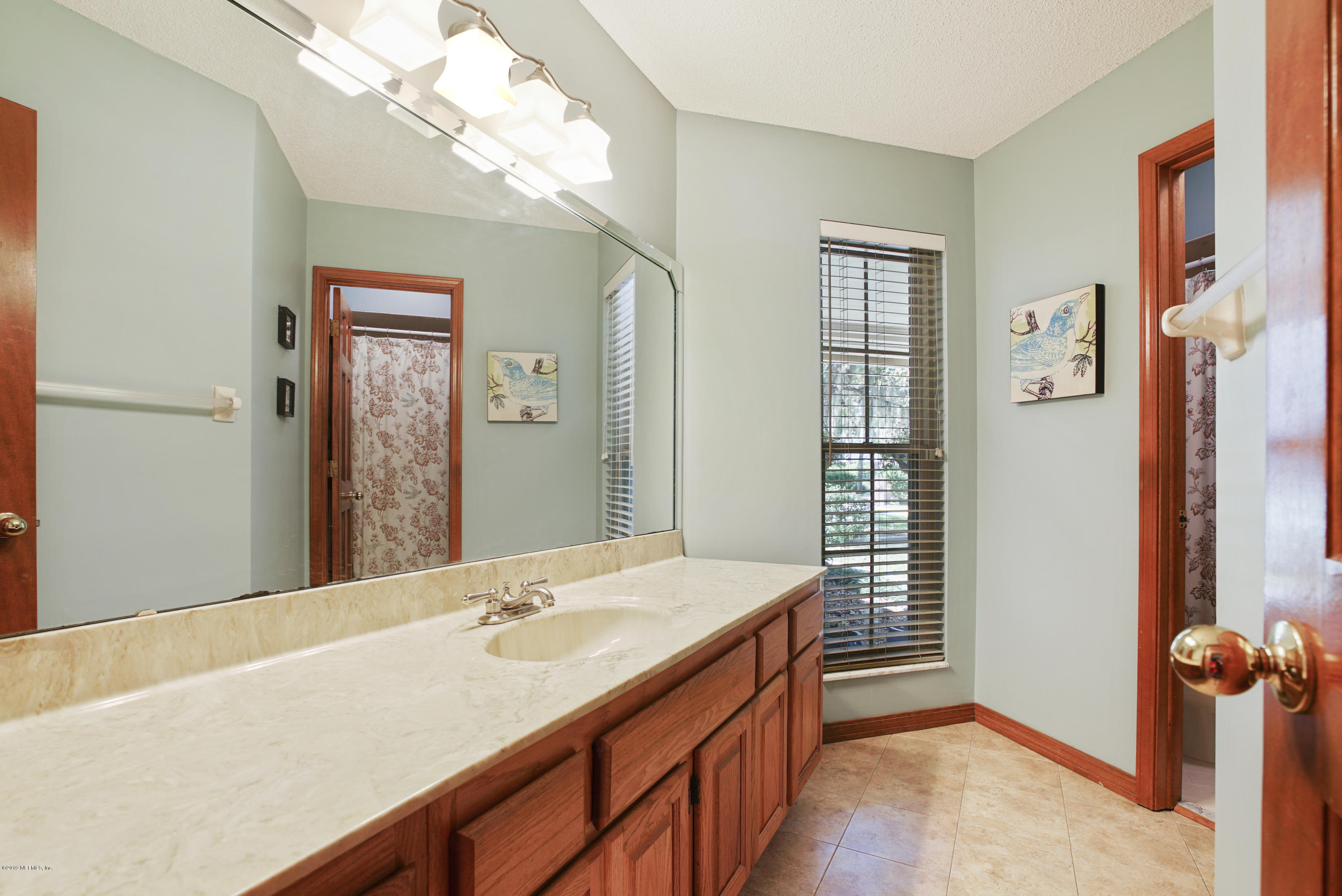 3165 Nautilus Road Middleburg, FL 32068 - Photo 21 of 35 a bathroom with a tub sink and mirror