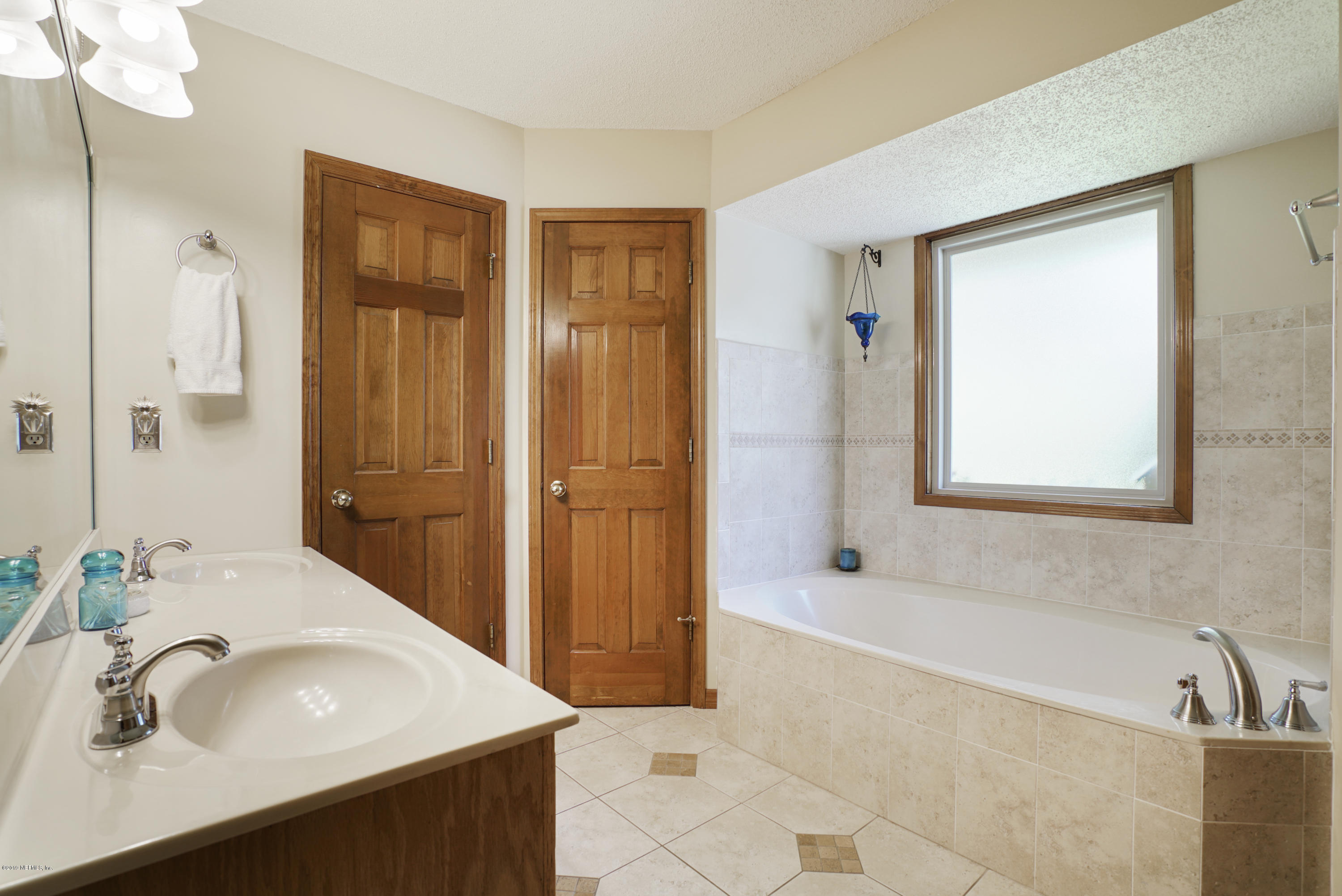 3165 Nautilus Road Middleburg, FL 32068 - Photo 25 of 35 a bathroom with a sink a tub and a mirror