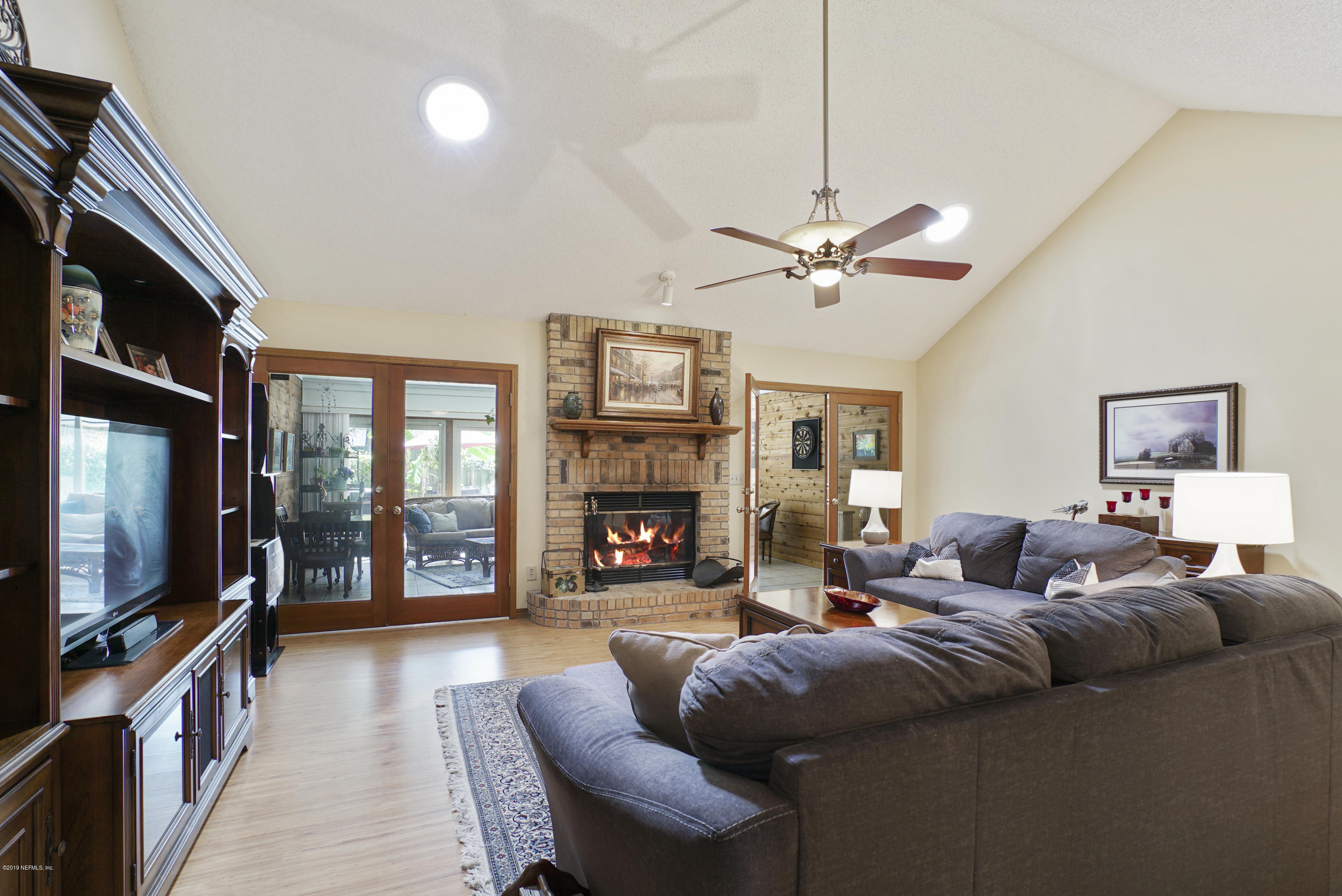 3165 Nautilus Road Middleburg, FL 32068 - Photo 7 of 35 a living room with furniture a fireplace and a flat screen tv
