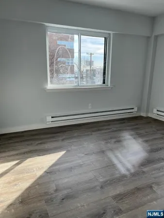 an empty room with wooden floor and a window