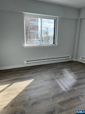an empty room with wooden floor and a window