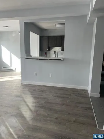 a view of a kitchen with furniture and wooden floor
