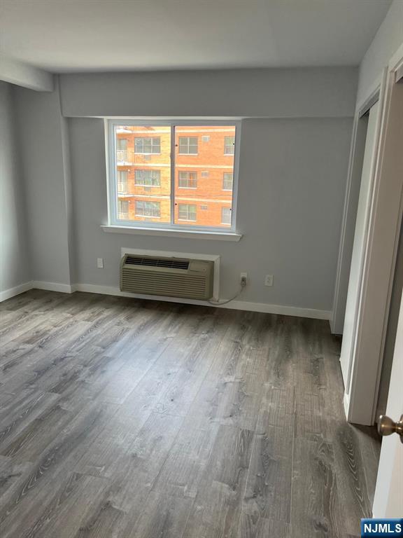47 Polifly Road, Unit 1A Hackensack, NJ 07601 - Photo 6 of 12 an empty room with wooden floor and windows