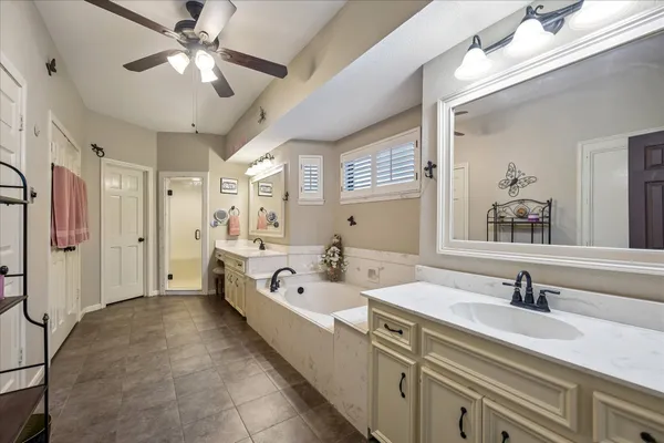 a spacious bathroom with a double vanity sink a mirror and shower