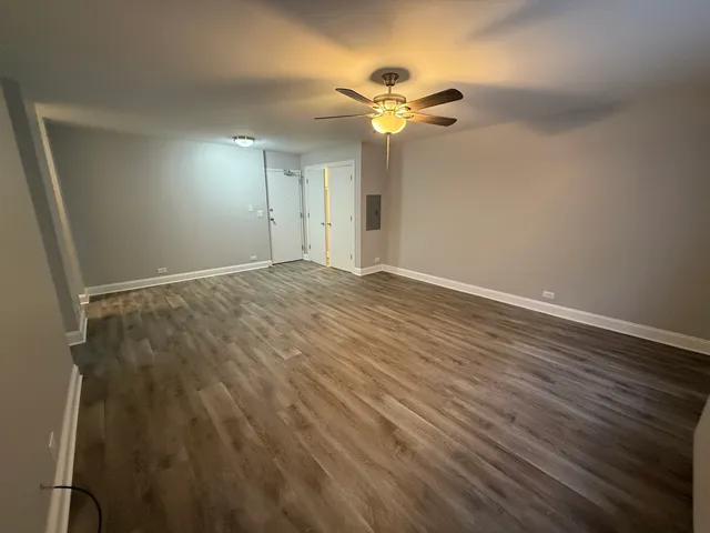a view of an empty room with wooden floor