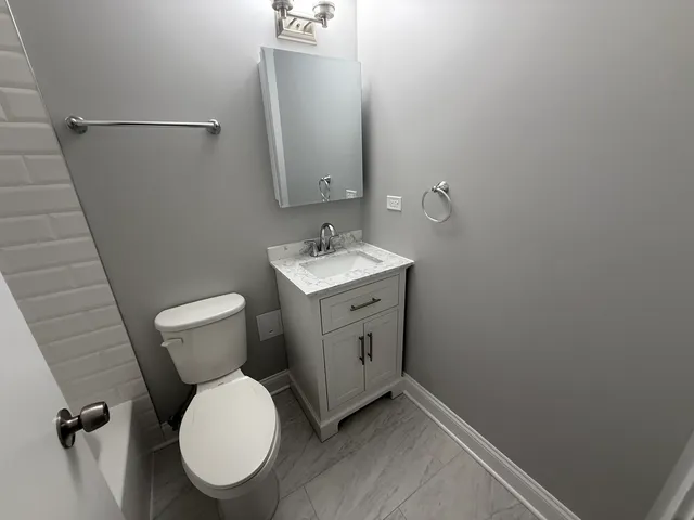 a bathroom with a toilet sink and a mirror