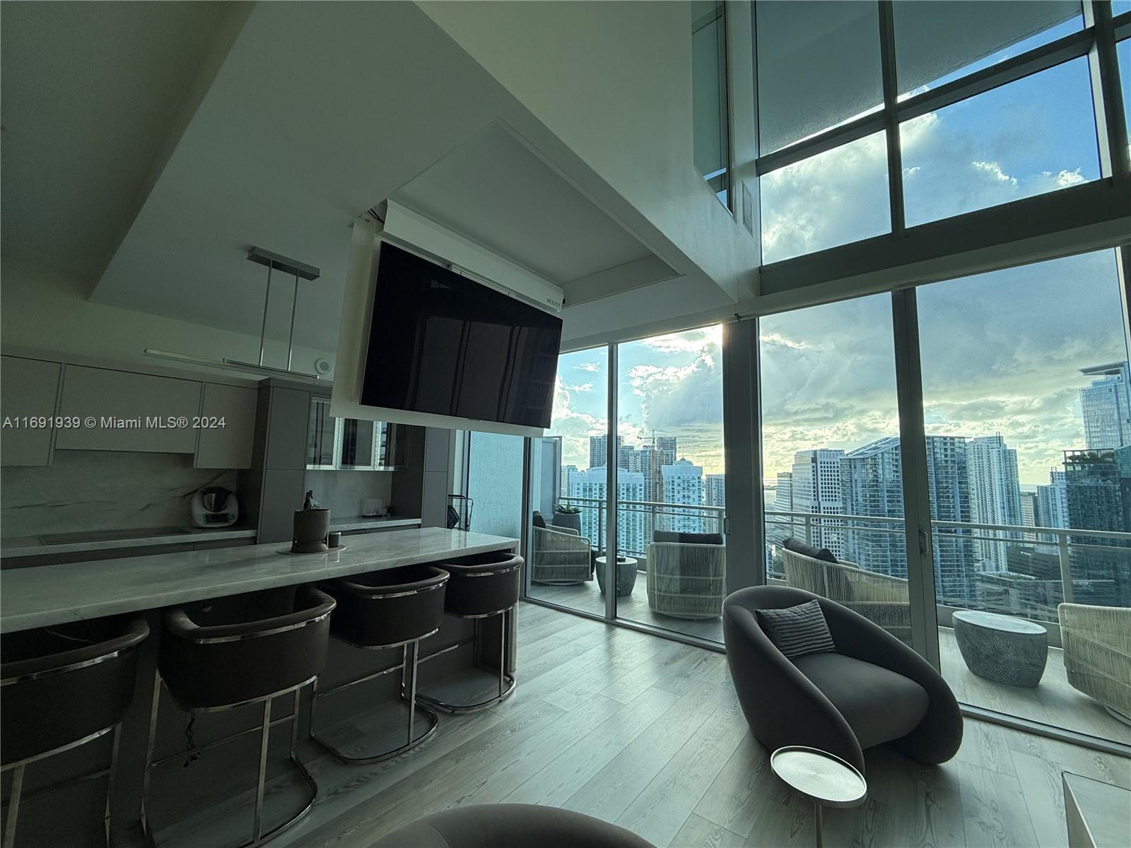 90 Southwest 3rd Street, Unit PH15 Miami, FL 33130 - Photo 16 of 18 a living room with furniture and a flat screen tv