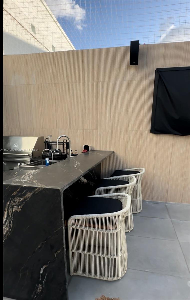 90 Southwest 3rd Street, Unit PH15 Miami, FL 33130 - Photo 17 of 18 a kitchen with a sink a stove and a microwave