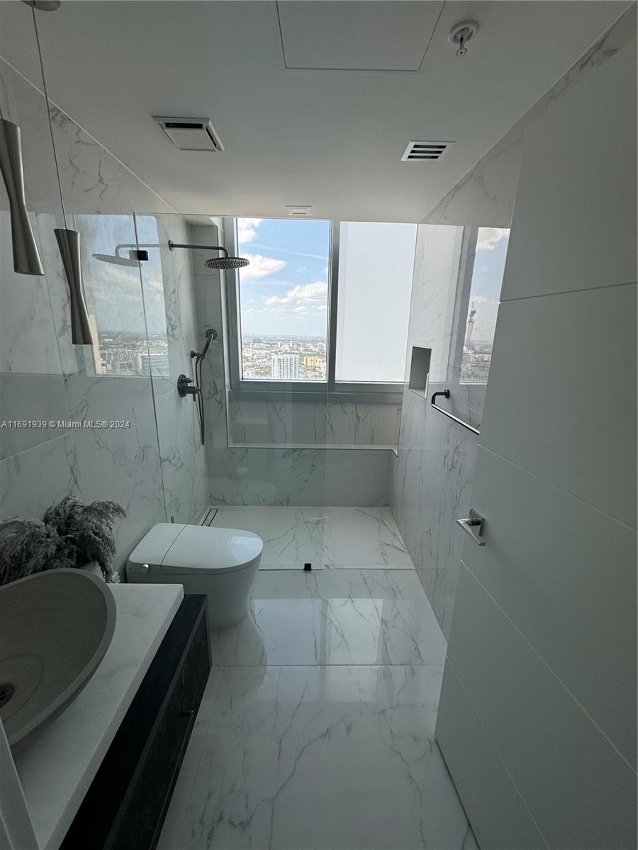 90 Southwest 3rd Street, Unit PH15 Miami, FL 33130 - Photo 10 of 18 a bathroom with a sink a toilet a mirror and shower