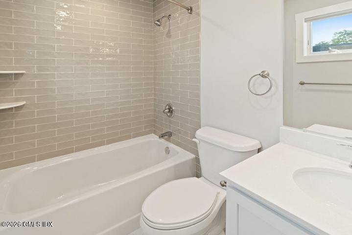 4 Orchard Street, Unit M Cos Cob, CT 06807 - Photo 11 of 19 a white toilet and tub sitting next to a bathroom sink