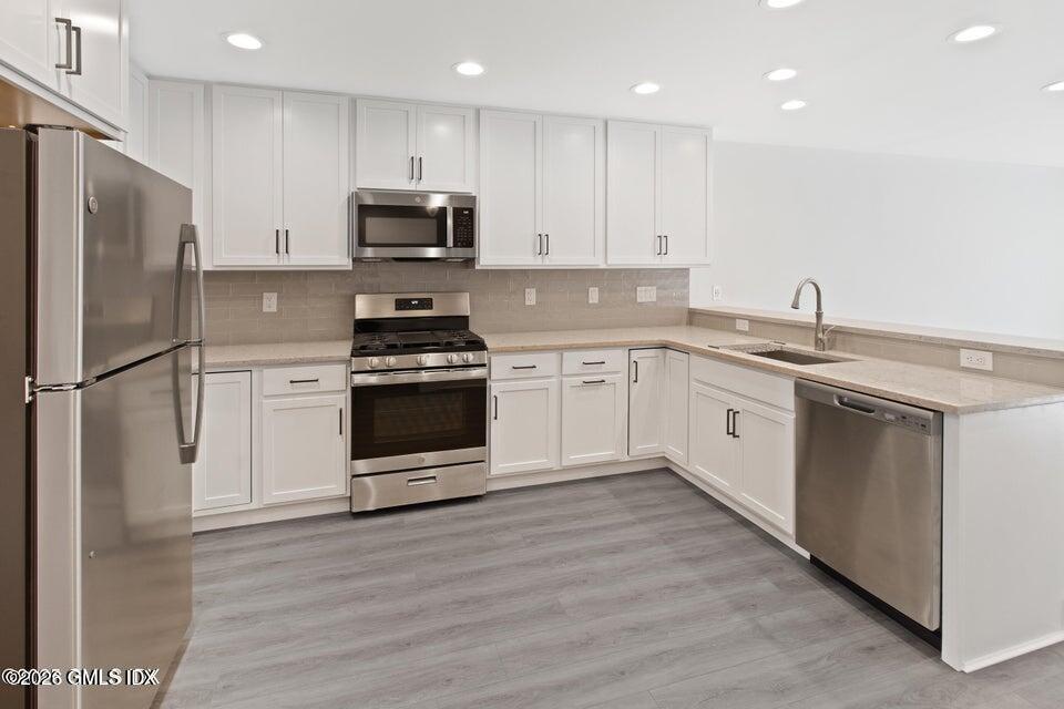4 Orchard Street, Unit M Cos Cob, CT 06807 - Photo 2 of 19 a kitchen with a sink stainless steel appliances and cabinets