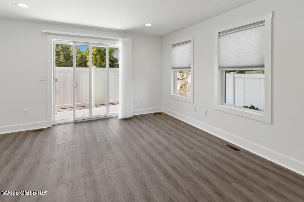 4 Orchard Street, Unit M Cos Cob, CT 06807 - Photo 4 of 19 an empty room with wooden floor and windows