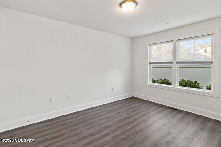 4 Orchard Street, Unit M Cos Cob, CT 06807 - Photo 9 of 19 an empty room with wooden floor and windows