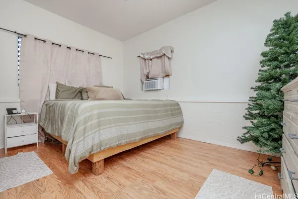 a bedroom with a bed and a potted plant