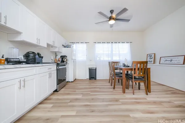 a kitchen with a table chairs and white appliances